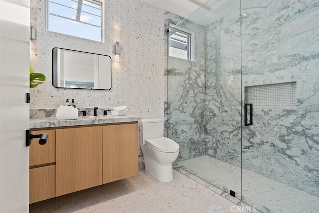 bathroom with tile patterned flooring, toilet, and tile walls