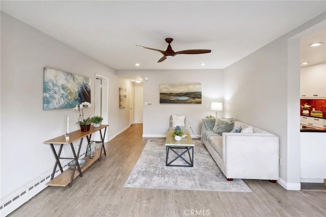 living room featuring ceiling fan and light hardwood / wood-style floors