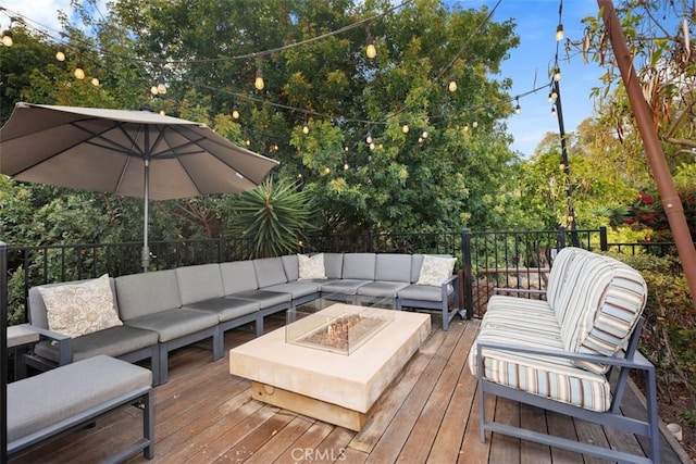 deck with an outdoor living space with a fire pit