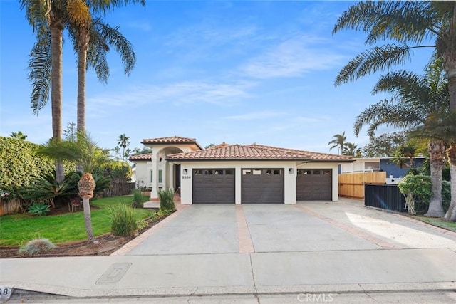 mediterranean / spanish home with a front yard and a garage