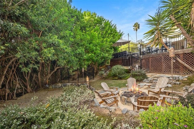 view of yard featuring a wooden deck and an outdoor fire pit