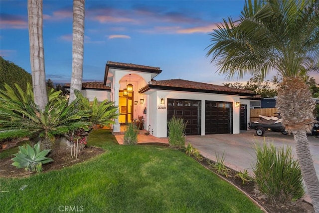 mediterranean / spanish-style house with a yard and a garage