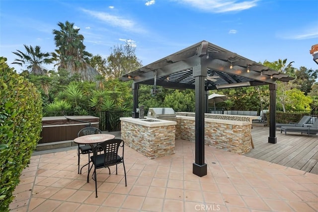 view of patio / terrace with a grill, a wooden deck, and exterior kitchen