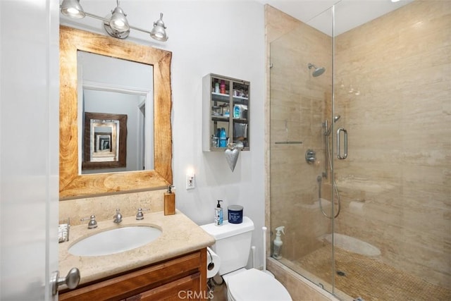 bathroom with vanity, toilet, and a shower with door