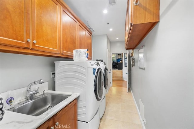 laundry area featuring cabinets, separate washer and dryer, sink, and light tile patterned floors