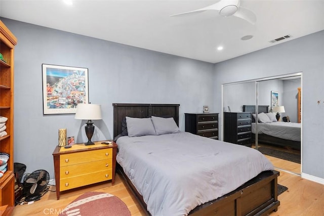 bedroom with ceiling fan, wood-type flooring, and a closet