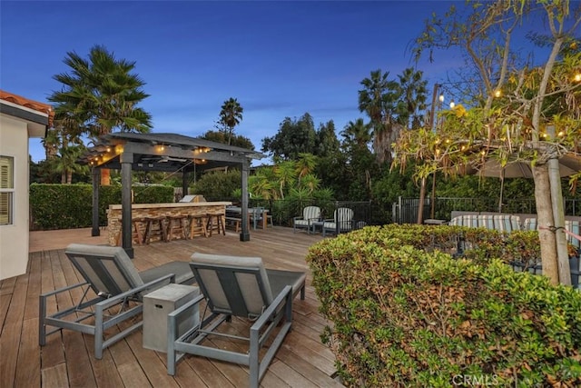 deck at dusk with a bar