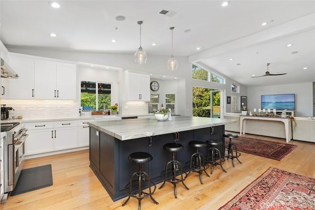 2308 S Ola Vis, San Clemente, CA 92672 - kitchen with a spacious island, vaulted ceiling with beams, white cabinetry, tasteful backsplash, and double oven range
