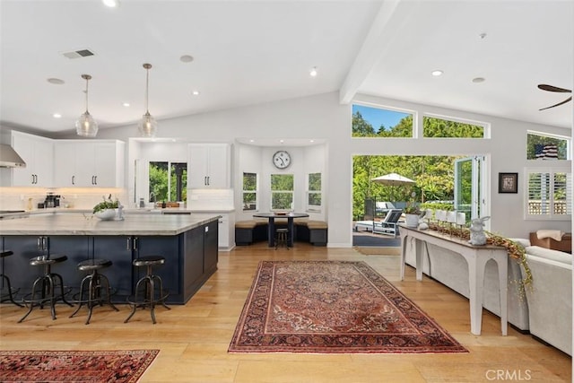 2308 S Ola Vis, San Clemente, CA 92672 - kitchen featuring white cabinets, beam ceiling, light wood-style flooring, decorative light fixtures, and visible vents