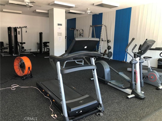 gym featuring a textured ceiling and ceiling fan