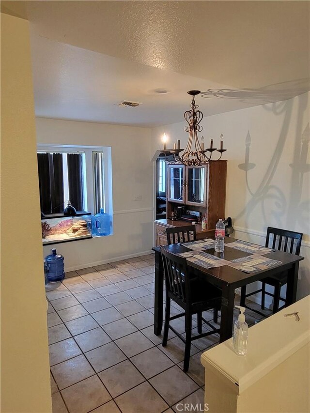 1912 Cortez St, Needles, CA 92363 - dining room with a chandelier, light tile patterned flooring, arched walkways, and a textured ceiling
