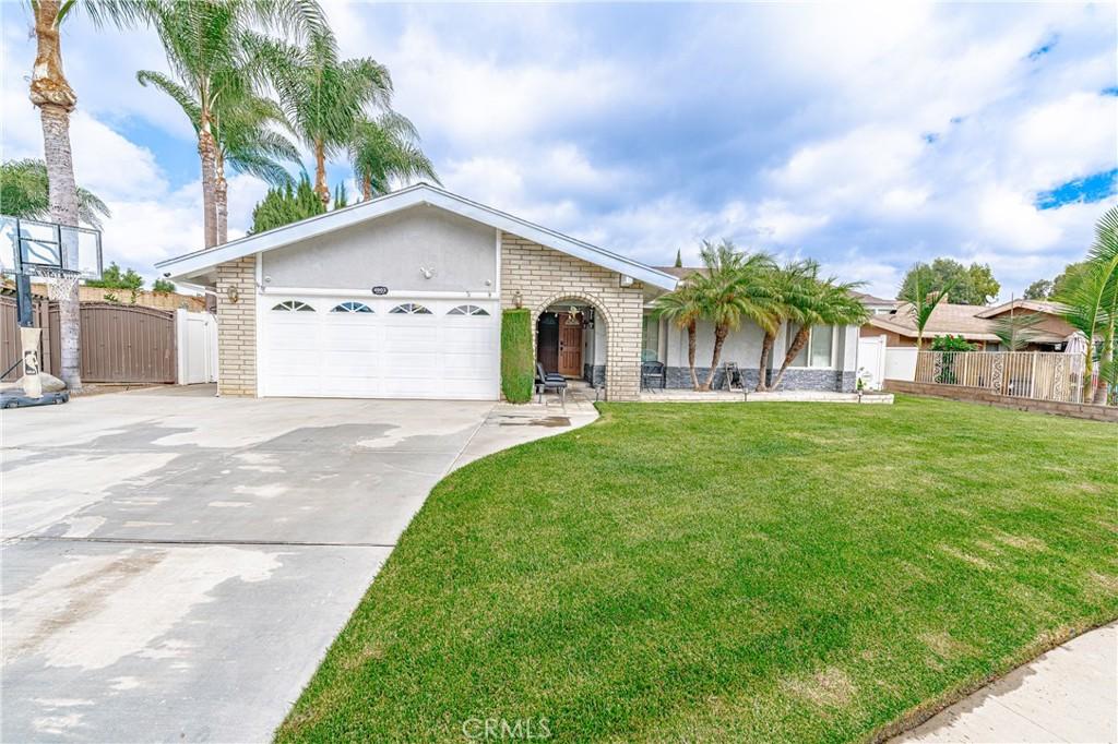 single story home with a garage and a front lawn