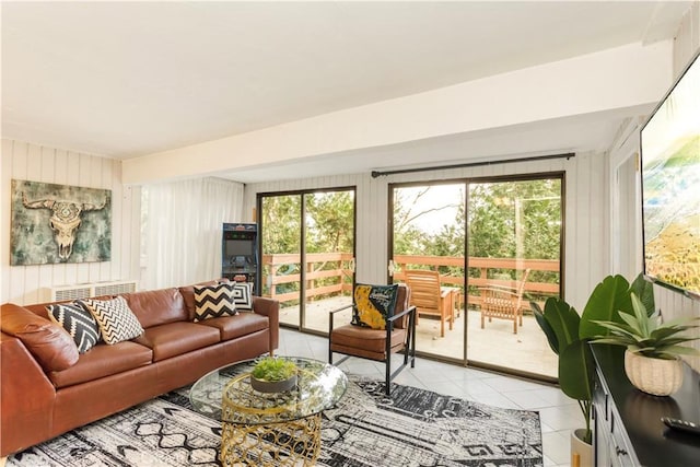 tiled living room featuring wood walls and plenty of natural light