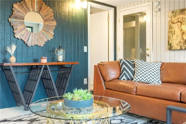 living room featuring tile patterned flooring and wooden walls