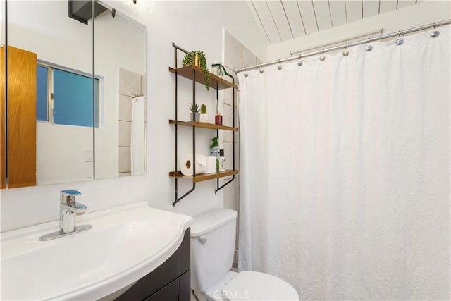 bathroom featuring toilet, lofted ceiling, and vanity