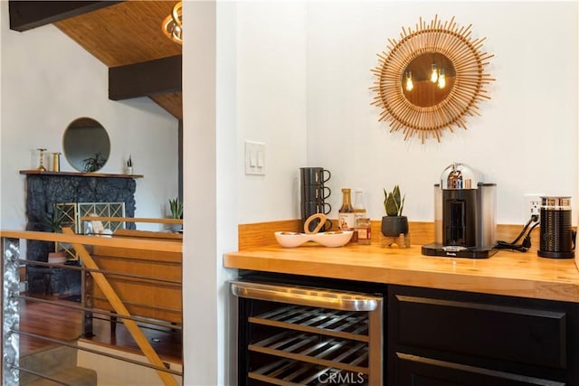 bar with wood ceiling, beverage cooler, wooden counters, and vaulted ceiling with beams