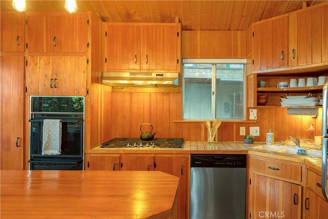 kitchen featuring butcher block counters, wood walls, wooden ceiling, appliances with stainless steel finishes, and sink