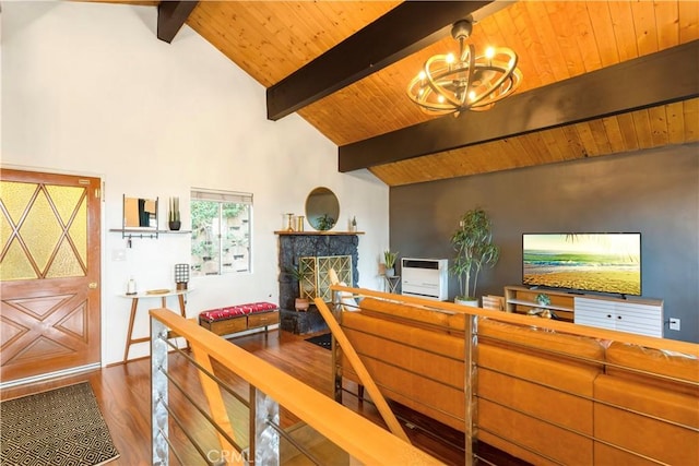 bedroom with a notable chandelier, lofted ceiling with beams, dark wood-type flooring, wood ceiling, and a stone fireplace