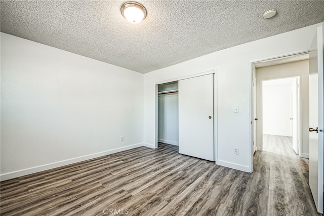 unfurnished bedroom featuring a closet, a textured ceiling, and hardwood / wood-style flooring