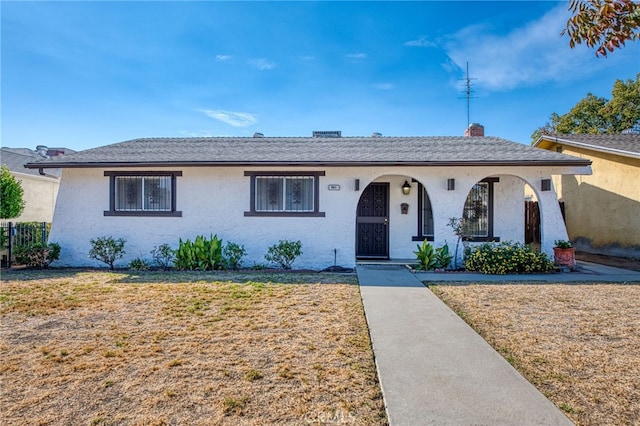 ranch-style house featuring a front lawn and covered porch