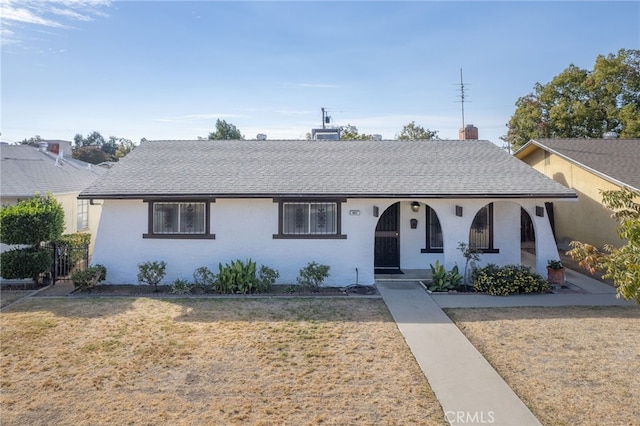 ranch-style home with a front lawn and covered porch