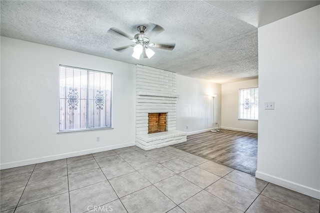 981 N Thorne Ave, Fresno, CA 93728 - unfurnished living room featuring a textured ceiling, a ceiling fan, tile patterned floors, and a fireplace