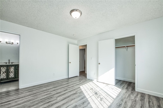 981 N Thorne Ave, Fresno, CA 93728 - unfurnished bedroom with wood finished floors, a textured ceiling, ensuite bathroom, and a closet