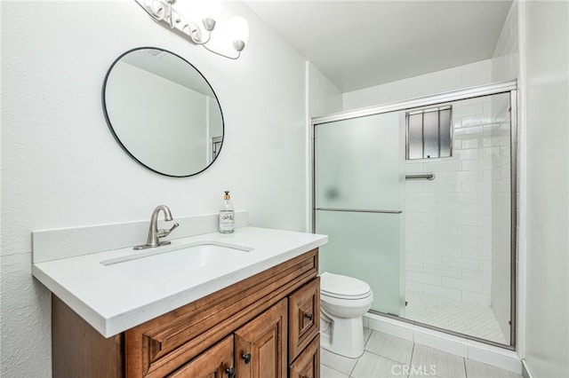 bathroom featuring tile patterned flooring, vanity, toilet, and a shower with door