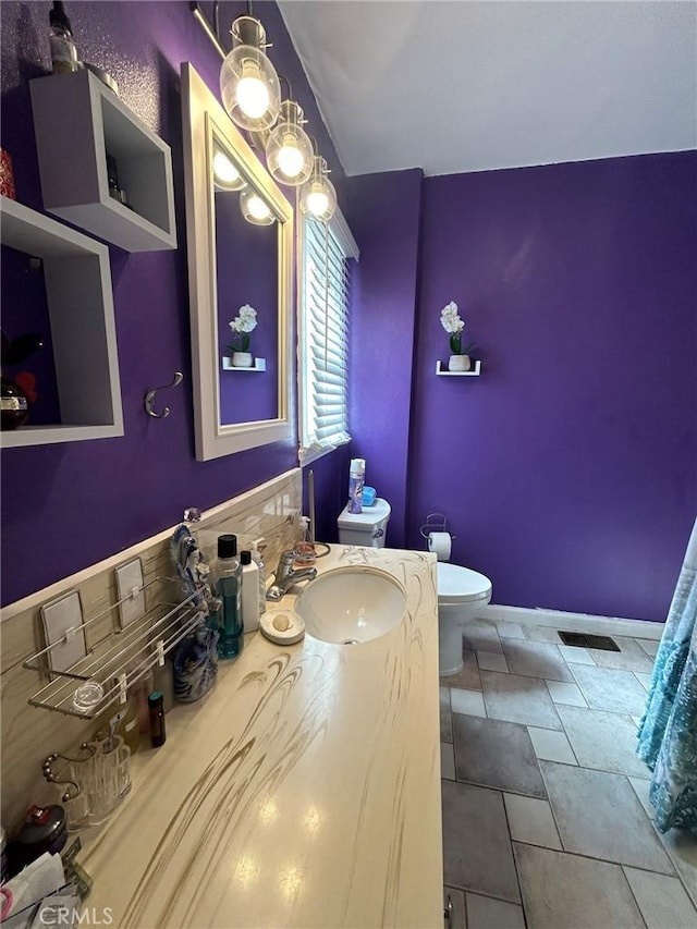 bathroom featuring decorative backsplash, vanity, and toilet