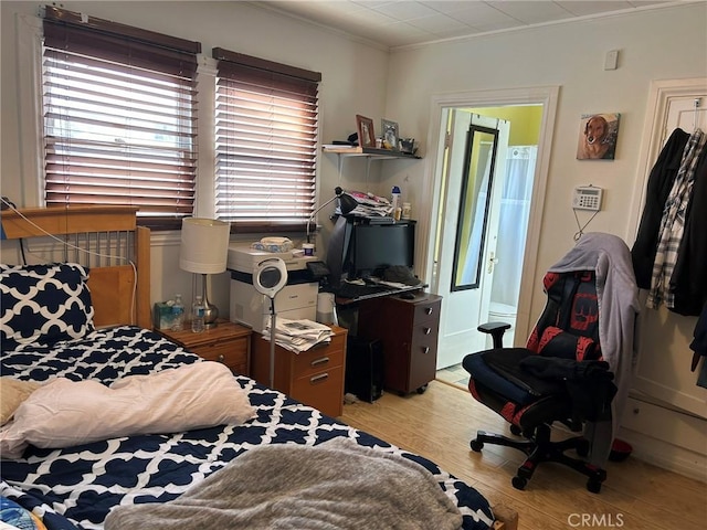 bedroom with ornamental molding and light hardwood / wood-style flooring