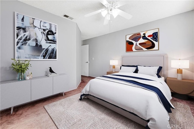 carpeted bedroom featuring ceiling fan and a textured ceiling