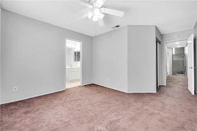 unfurnished room featuring a textured ceiling, ceiling fan, and carpet floors