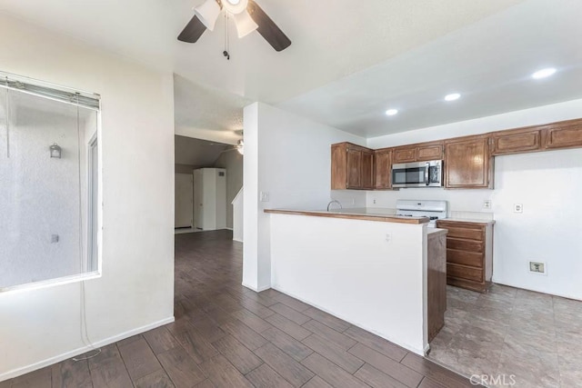 kitchen featuring ceiling fan, kitchen peninsula, dark wood-type flooring, and white range