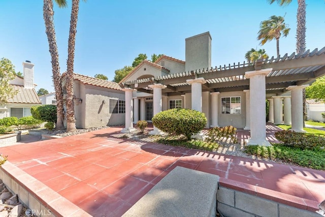 rear view of property featuring a pergola