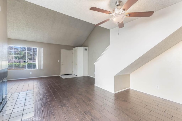 unfurnished living room with ceiling fan, a textured ceiling, hardwood / wood-style flooring, and lofted ceiling