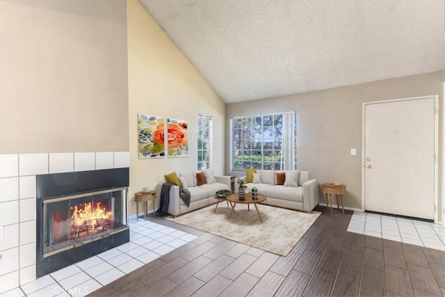 living room with a textured ceiling, lofted ceiling, and a tile fireplace