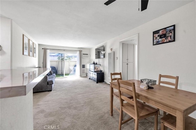 dining space with ceiling fan, light colored carpet, and a wall mounted AC