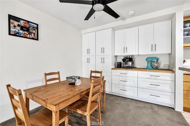 carpeted dining room featuring ceiling fan