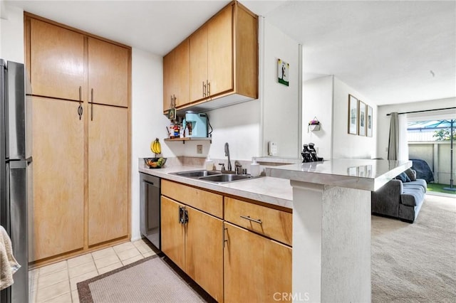 kitchen with light carpet, appliances with stainless steel finishes, kitchen peninsula, and sink