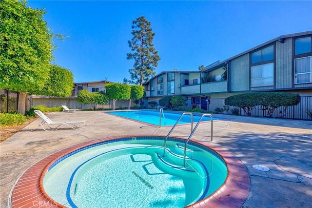 view of swimming pool with a patio area and a community hot tub