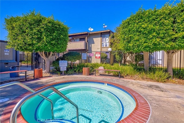 view of swimming pool with a hot tub