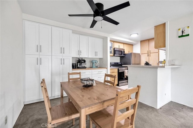 carpeted dining room with ceiling fan