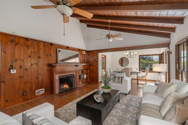 living room featuring a fireplace, hardwood / wood-style floors, wooden ceiling, and wood walls