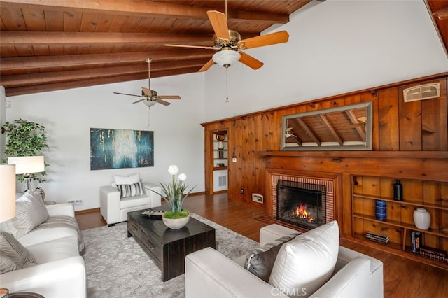 living room with vaulted ceiling with beams, a brick fireplace, wood ceiling, and wood-type flooring