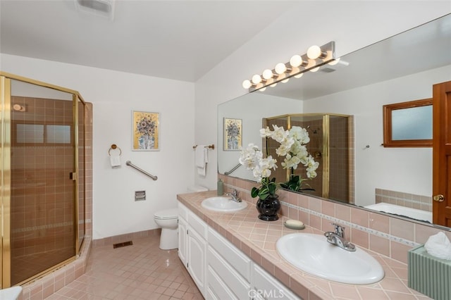 bathroom with backsplash, vanity, a shower with door, tile patterned flooring, and toilet