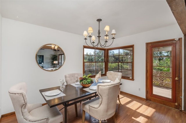 dining space with wood-type flooring and a notable chandelier