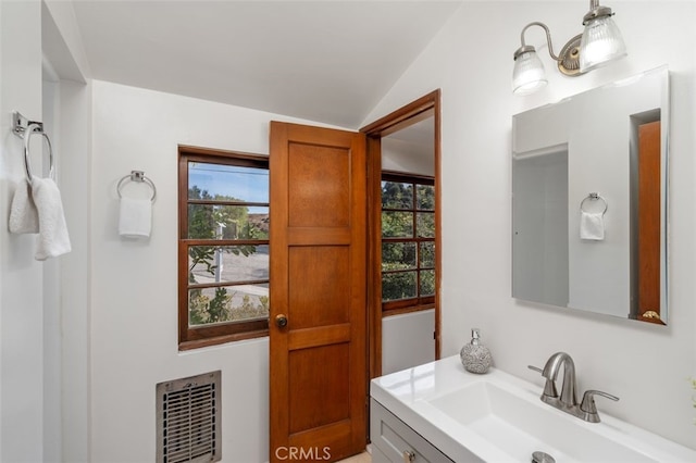 bathroom with heating unit, vanity, and vaulted ceiling