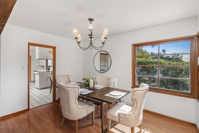 dining area featuring a chandelier, sink, and light hardwood / wood-style flooring