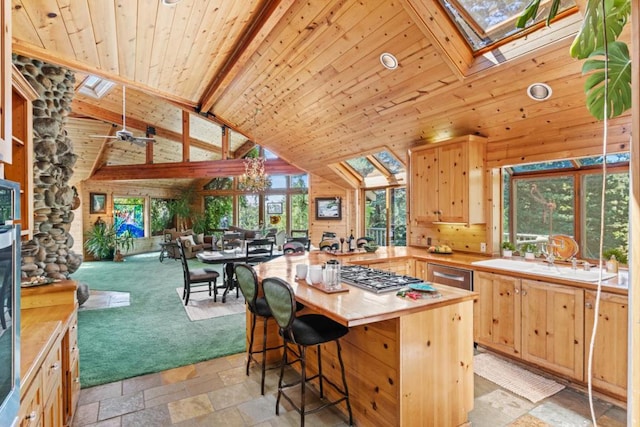 kitchen with beam ceiling, a skylight, wooden ceiling, and light brown cabinets