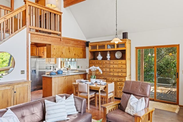 kitchen with beamed ceiling, appliances with stainless steel finishes, high vaulted ceiling, and kitchen peninsula